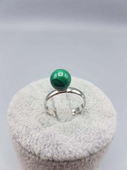 Un ANELLO SOLITARIO DI MALACHITE con sopra una pietra verde.