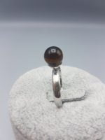 A TIGER'S EYE SOLITAIRE RING with a brown stone on it.