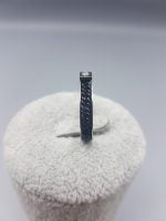 A STEEL RING WITH GLITTER with a diamond in the center.