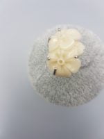 Un ANELLO FIORE BIANCO IN RESINA con fiori bianchi sopra.