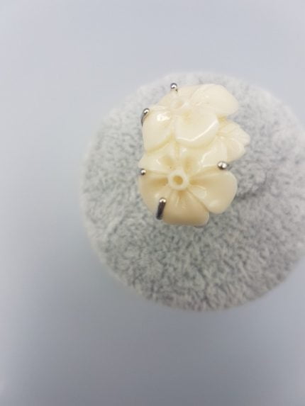 Un ANELLO FIORE BIANCO IN RESINA con fiori bianchi sopra.