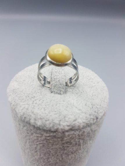 Un ANELLO DI OCCHIO DI TIGRE TONDO GIALLO con sopra una pietra gialla.