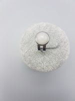A WHITE JADE RING with a white stone on it.