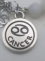 A MEN'S BRACELET WITH MOONSTONE AND BLACK ONYX WITH CANCER PENDANT with the inscription cancer on it.
