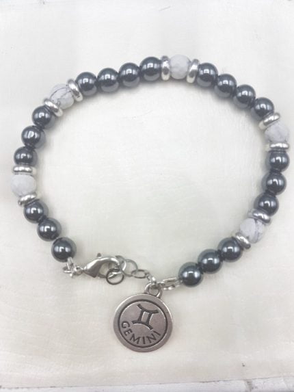 A BRACCIALE DI EMATITE E HOWLITE CON CIONDOLO GEMELLI con grani in argento.