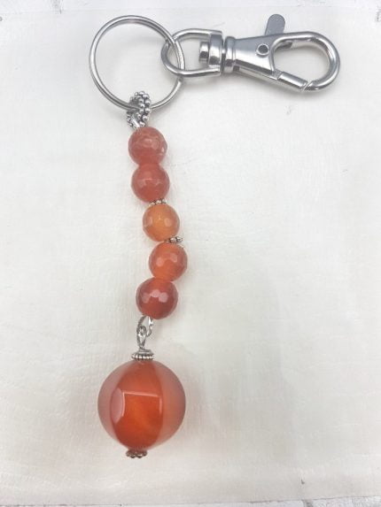 A KEYCHAIN WITH ORANGE CARNELIAN on a white background.