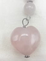 Un pendente a forma di cuore con quarzo rosa e una catena d'argento.