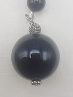 A keychain with black onyx hanging from a silver chain.