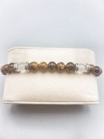 A men's tiger's eye and rock crystal bracelet with scorpion pendant in a box.