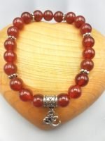 UN BRACCIALE DI CORNIOLA CON CIONDOLO OM.