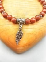 Un bracciale con charm foglia e argento.
Nome Prodotto: UN BRACCIALE DI DIASPRO ROSSO CON PIUMA con charm foglia e argento.