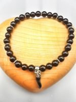 A BLACK ONYX BRACELET WITH BLACK ENAMELLED HORN with silver charm.