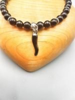 A black onyx bracelet with a black enamel croissant.