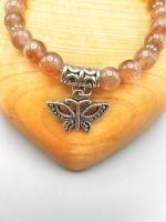 A bracelet with a butterfly pendant on it.