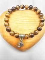 A 8MM TIGER'S EYE BRACELET WITH OM PENDANT.