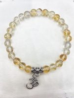 Un braccialetto con perline di quarzo citrino e un ciondolo OM.