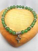 A green aventurine bracelet with a silver key pendant.