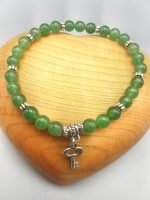 Un bracciale di avventurina verde con un ciondolo chiave in argento.