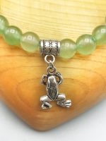 A green aventurine bracelet with a silver frog pendant.