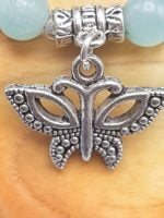 A 6 MM AMAZONITE BRACELET WITH BUTTERFLY charm on wooden bead.