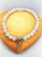 A white moonstone bracelet with key pendant.