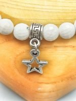 Un bracciale di agata bianca da 6 mm con ciondolo stella.