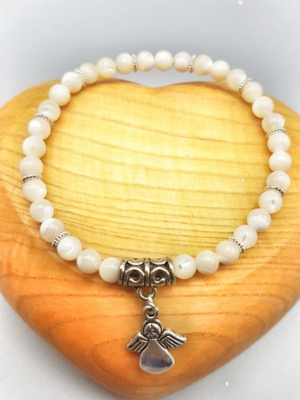 Un braccialetto bianco con perline e ciondolo angelo.