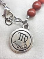 Un braccialetto con sopra il nome del prodotto BRACCIALE UOMO DI DIASPRO ROSSO ED EMATITE CON CIONDOLO DELLA VERGINE.