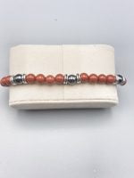 Un bracciale con grani di corallo rosso e grani d'argento.