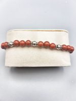 Un braccialetto con perle di diaspro rosso e perle d'argento.
