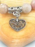 A RHODONITE BRACELET WITH HEART PENDANT made of rhodonite.