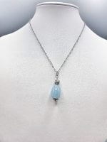 A large barrel aquamarine pendant with a blue aquamarine stone.
