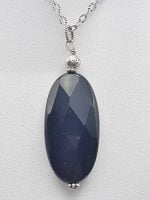 UN CIONDOLO IN ONICE NERA OVALE con pietra ovale blu su catena in argento.