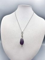 Una collana di ametiste e diamanti su un manichino con CIONDOLO DI FLUORITE VIOLA.