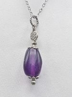 Un ciondolo di fluorite viola sulla catena d'argento.