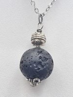 A lava stone pendant with a blue stone on it.