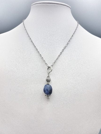 Un CIONDOLO DI SODALITE appeso a una collana d'argento.