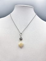 Una collana con un CIONDOLO DI MADREPERLA e una catena d'argento.