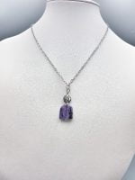 The SUGILITE PENDANT on a silver chain.