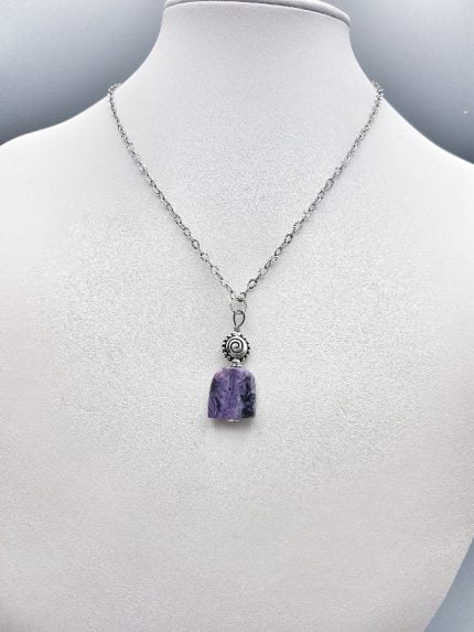 The SUGILITE PENDANT on a silver chain.