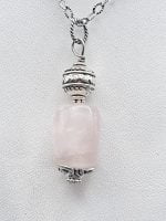 Un CIONDOLO DI QUARZO ROSA BARILOTTO su una catena d'argento.