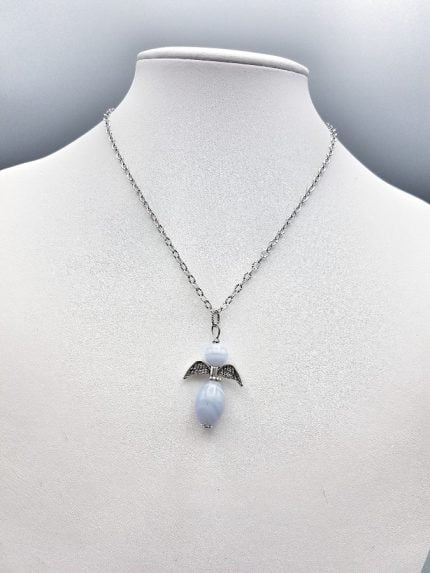 An angel chalcedony pendant on a mannequin.