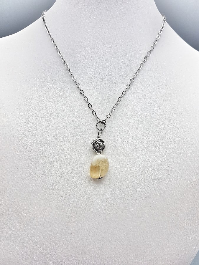 Una collana con un CIONDOLO DI QUARZO CITRINO SASSO e una catena in argento.