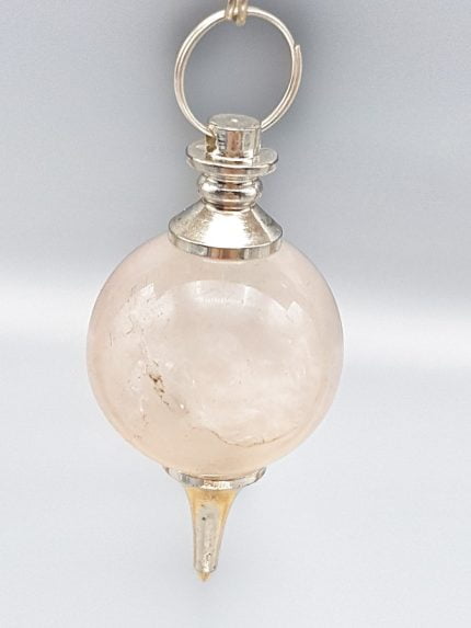 Un pendolo in quarzo rosa sferico appeso a una catena d'argento.