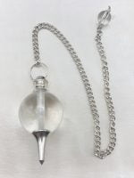 A spherical rock crystal pendulum with a silver chain attached to it.