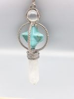 A necklace with a rock crystal pendulum and merkabah stone in blue howlite and a white stone.
