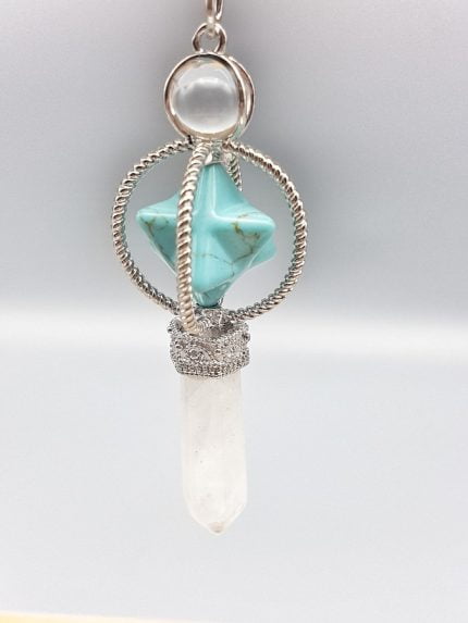 A necklace with a rock crystal pendulum and merkabah stone in blue howlite and a white stone.