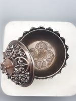 A SMALL FLOWER DORJE INCENSE BURNER on a white plate.