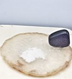 BURN INCENSE SLICE OF WHITE AGATE sitting on a white plate.