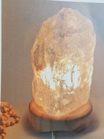 A ROCK CRYSTAL LAMP 2/3 KG with a stone on it.